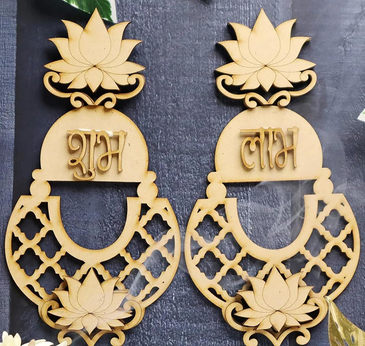 Pair of decorative earrings with lotus designs and text on a dark background