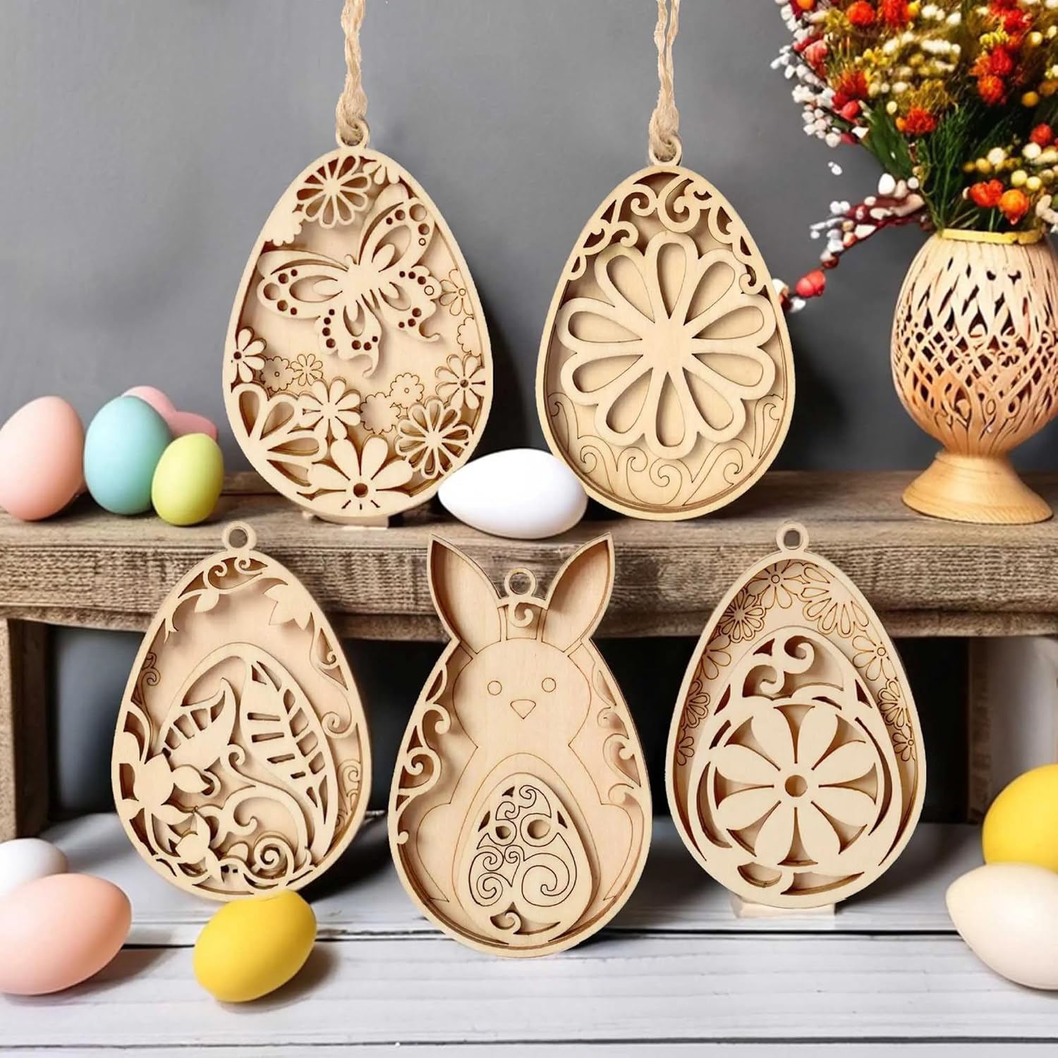 Wooden Easter egg ornaments with intricate cut-out designs on a wooden shelf.