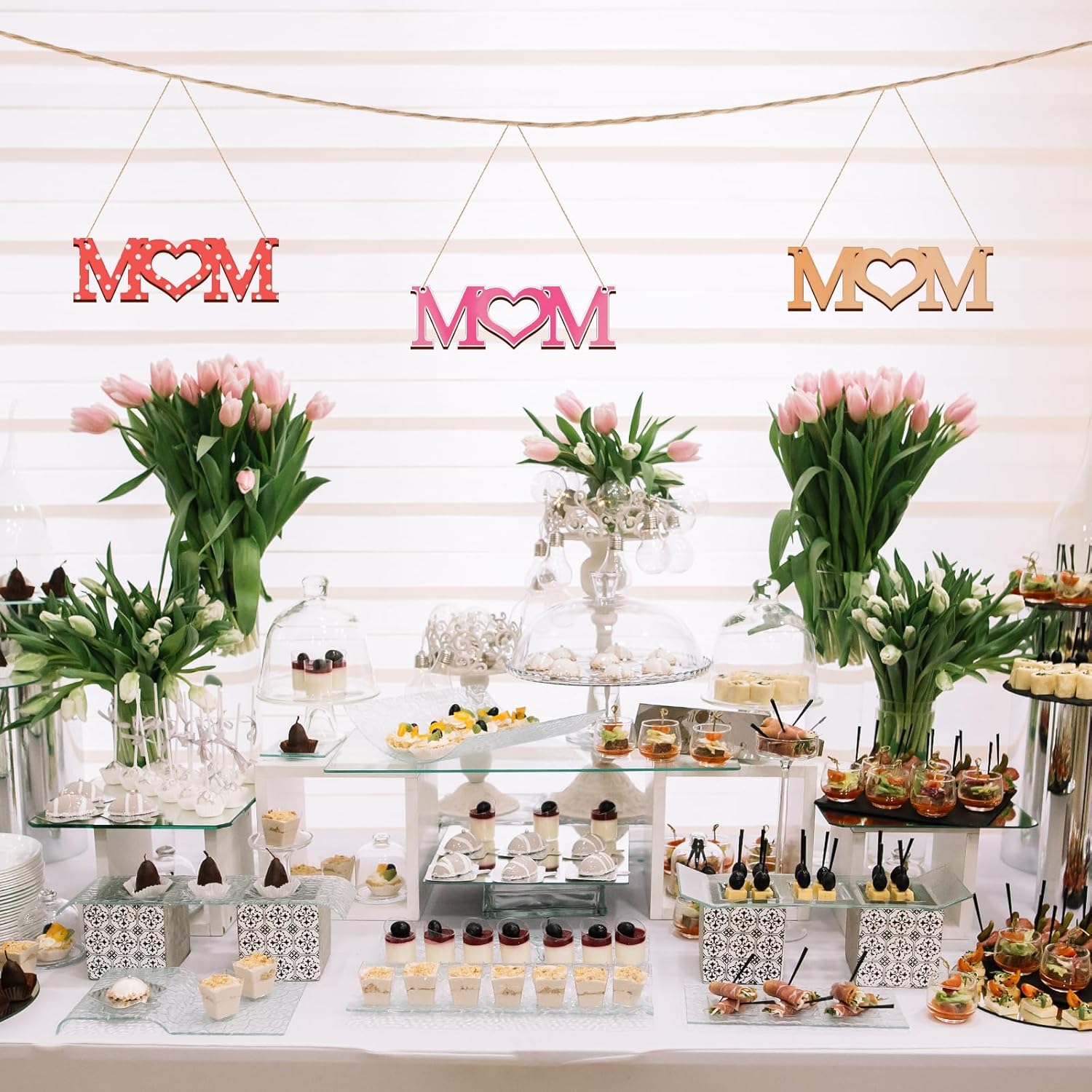 Decorative setup with 'MOM' signs and floral arrangements on a white background