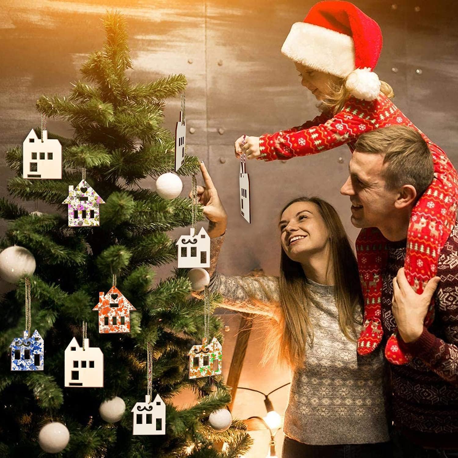 Family decorating a Christmas tree with ornaments, wearing festive clothing.