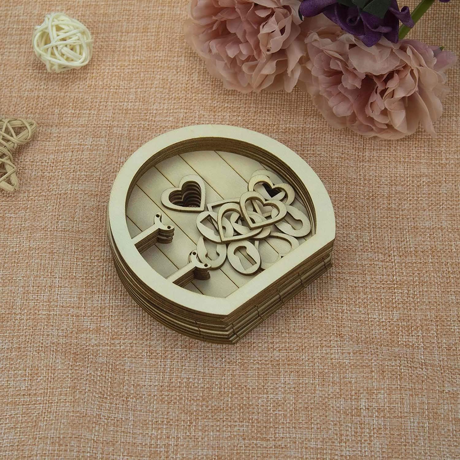 Wooden heart-shaped decorative item with cut-out letters on a textured fabric background with flowers.