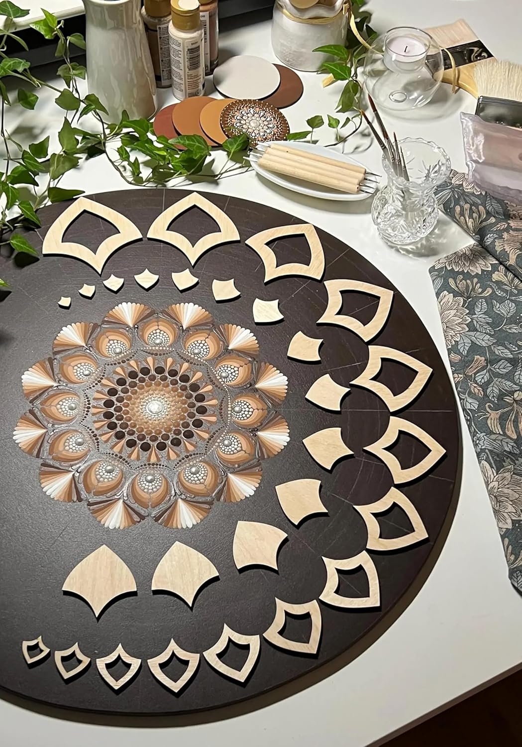 Decorative round mat with geometric design on a table with candles and greenery