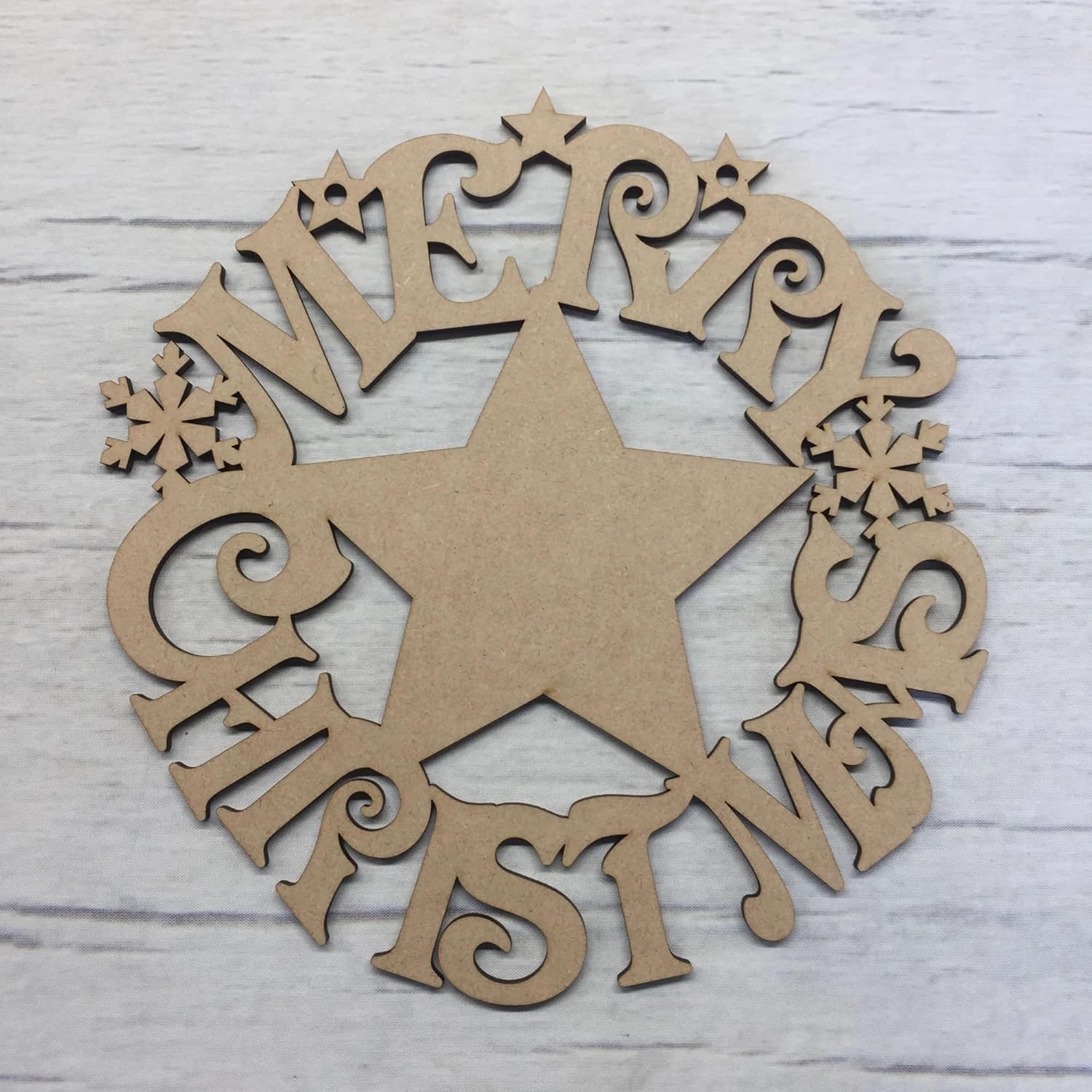 Wooden Christmas star decoration with 'Merry Christmas' cutout letters on a light wooden background