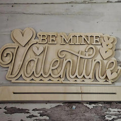 Wooden sign with 'Be Mine Valentine' text on a rustic wooden background