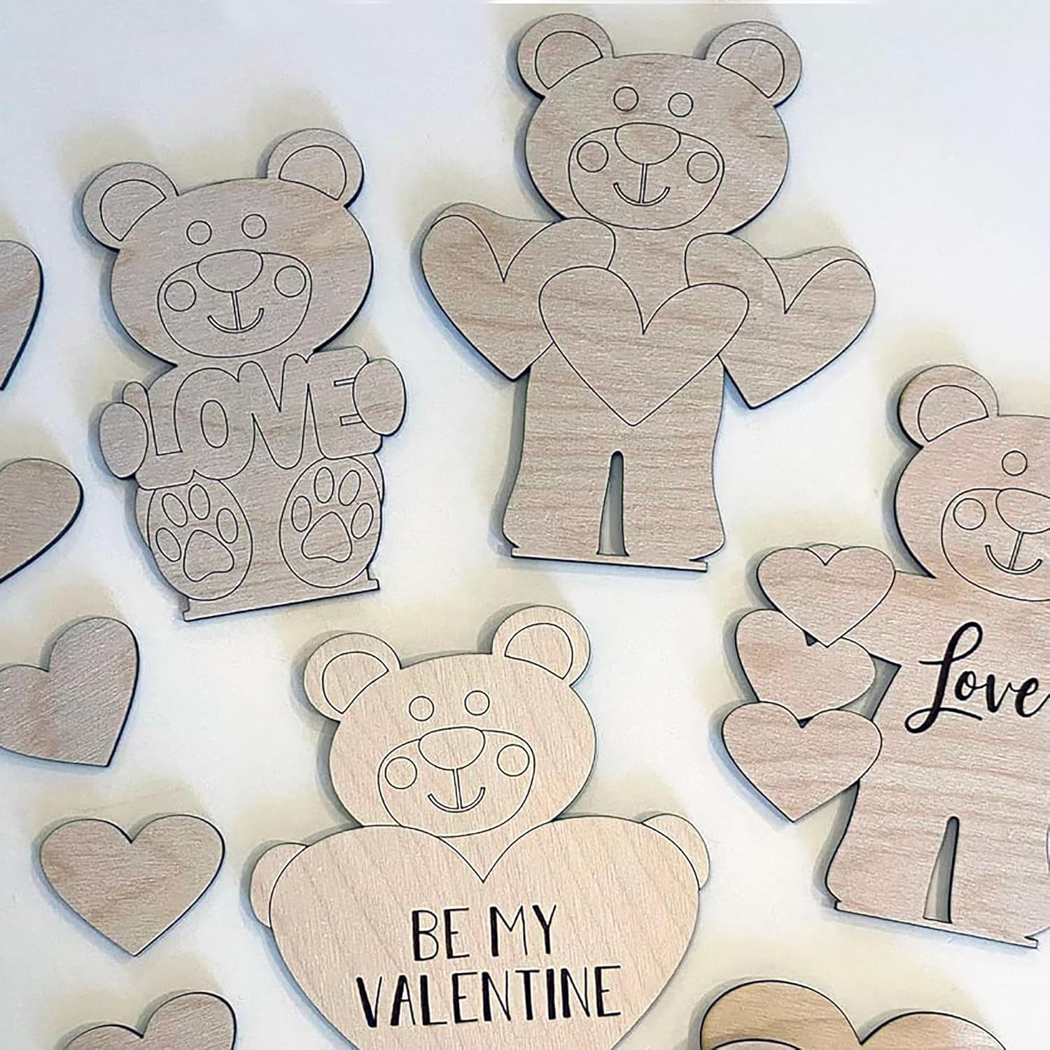 Wooden bear and heart shapes with 'love' and 'be my valentine' text on a light background