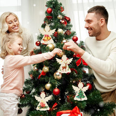 Family decorating a Christmas tree with ornaments and lights.