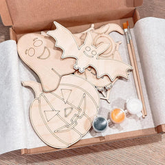 Wooden Halloween-themed cutouts with paint supplies in a box