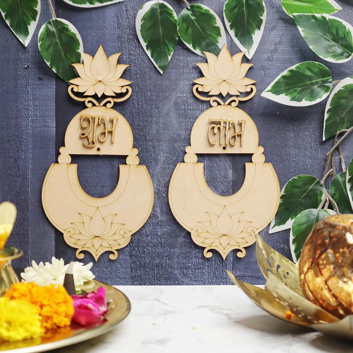 Decorative wooden earrings with intricate designs on a blue background with leaves.