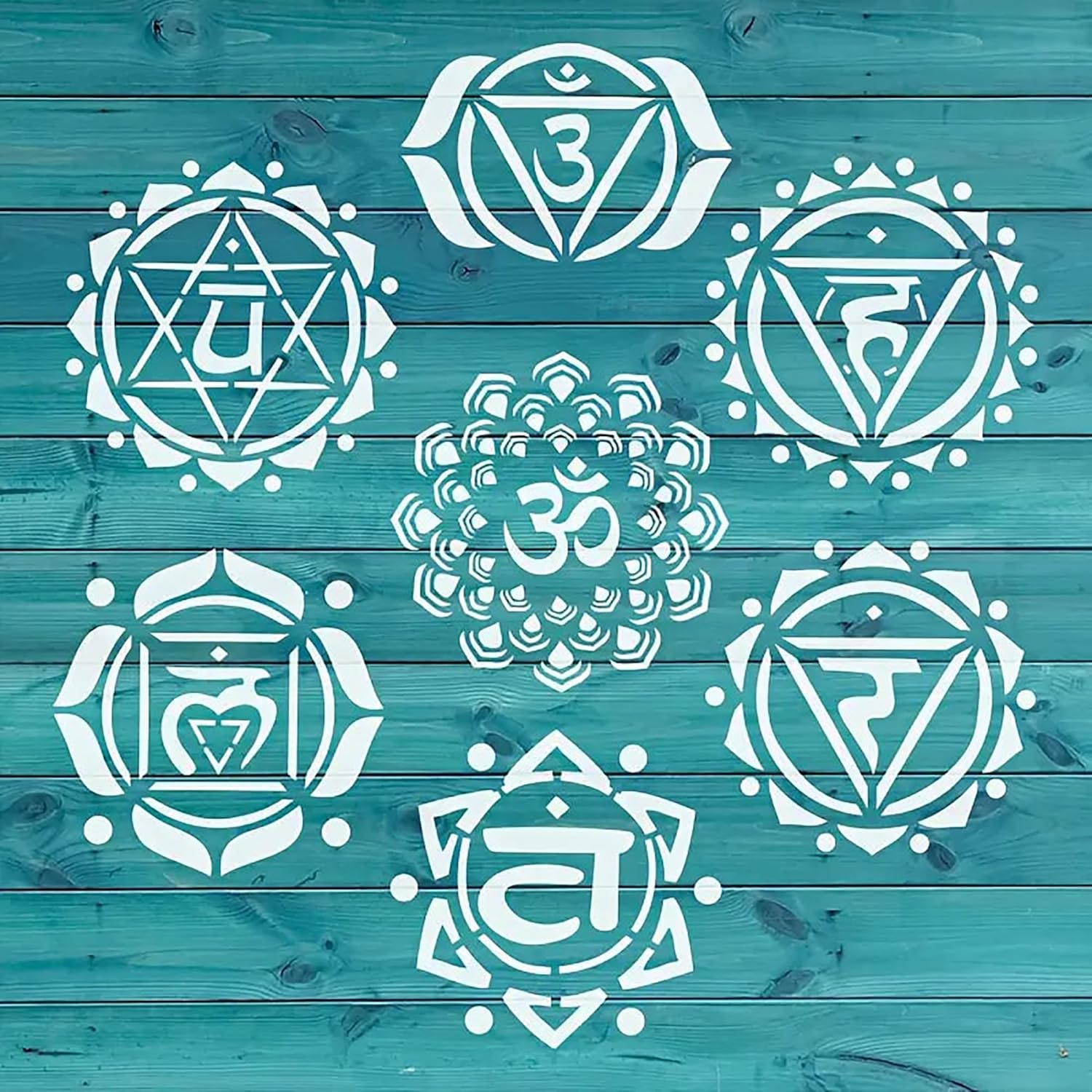 Set of white chakra symbols on a teal wooden background
