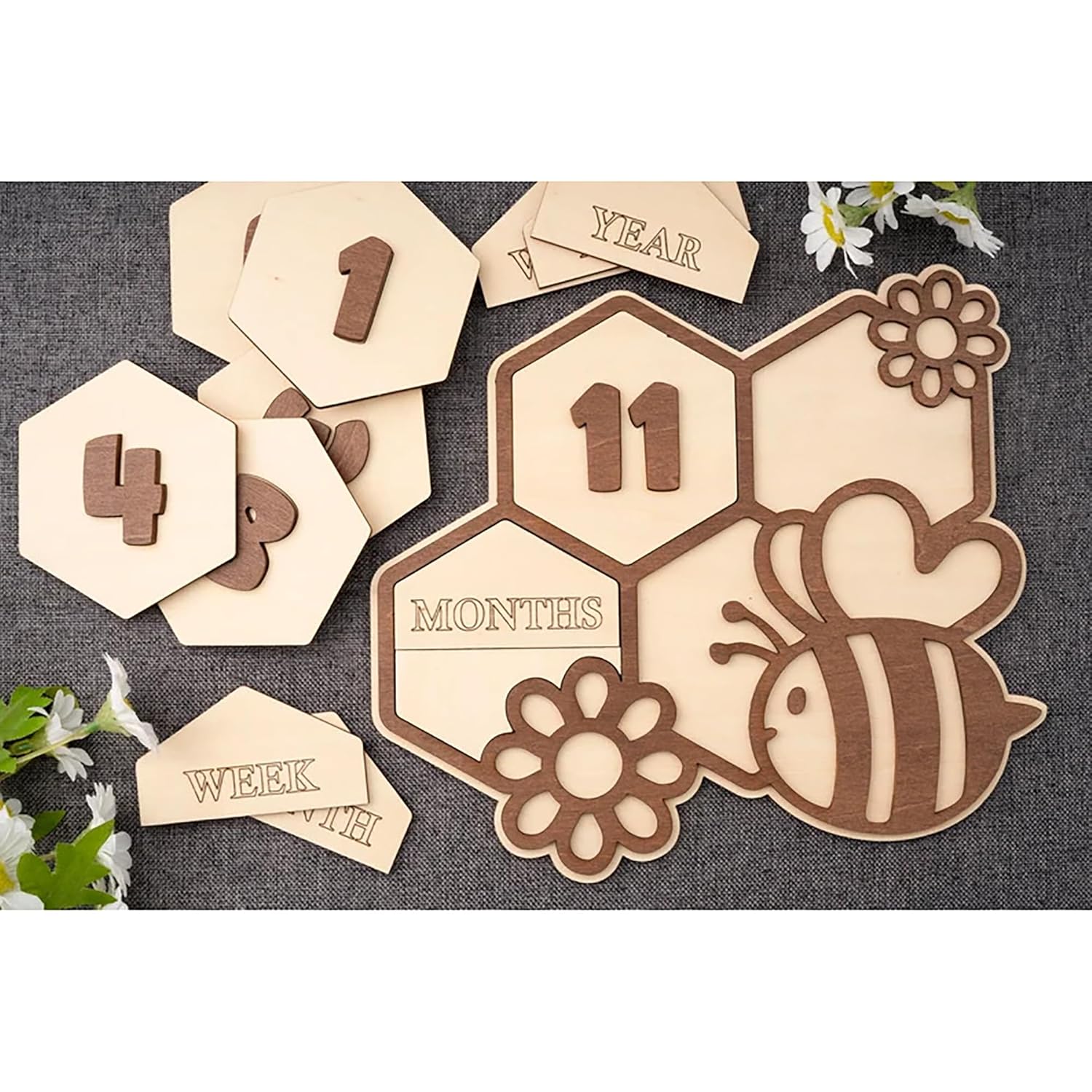 Wooden baby milestone cards with numbers and a bee design on a textured surface.