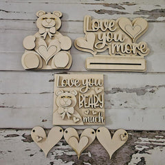 Wooden decorative items with teddy bear and heart designs on a rustic wooden background