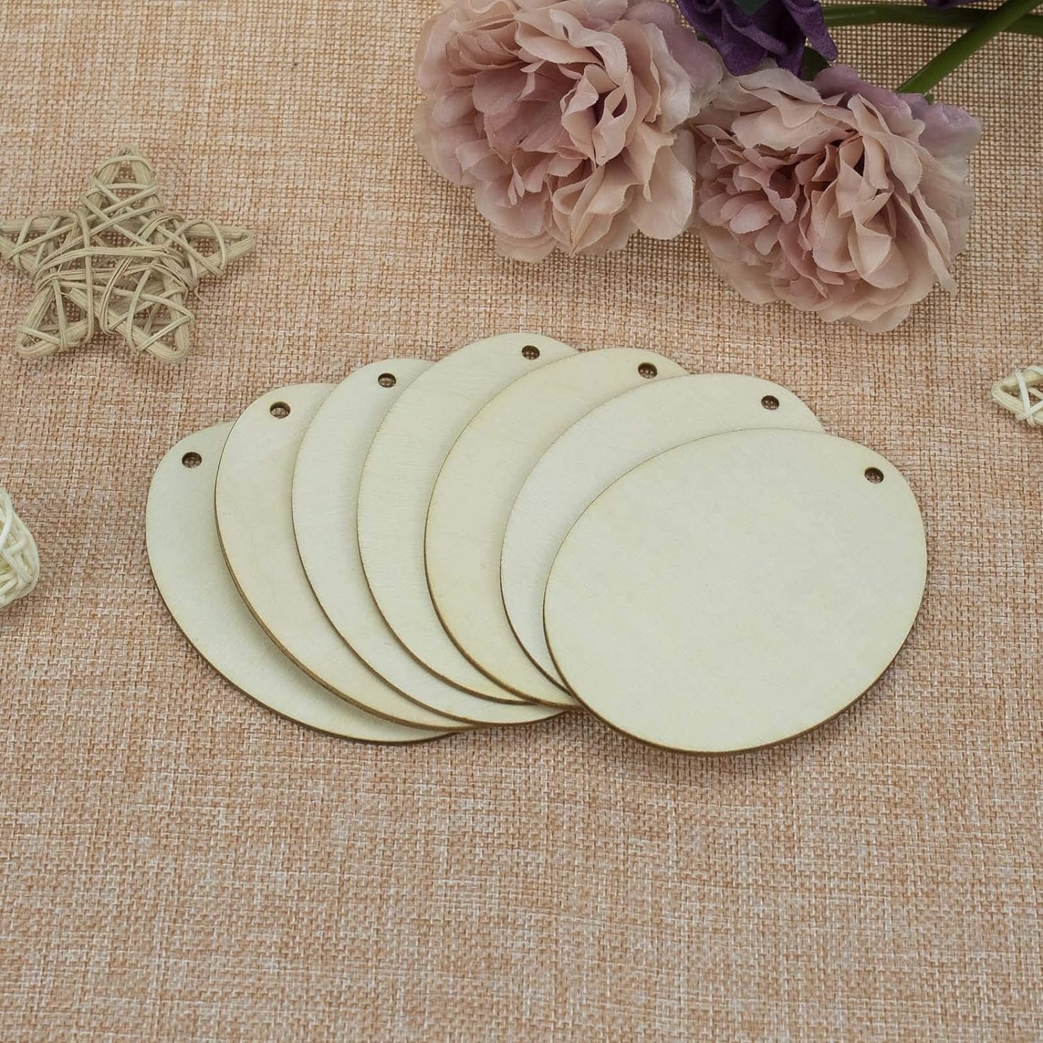 Set of round wooden tags on a textured fabric background with flowers.