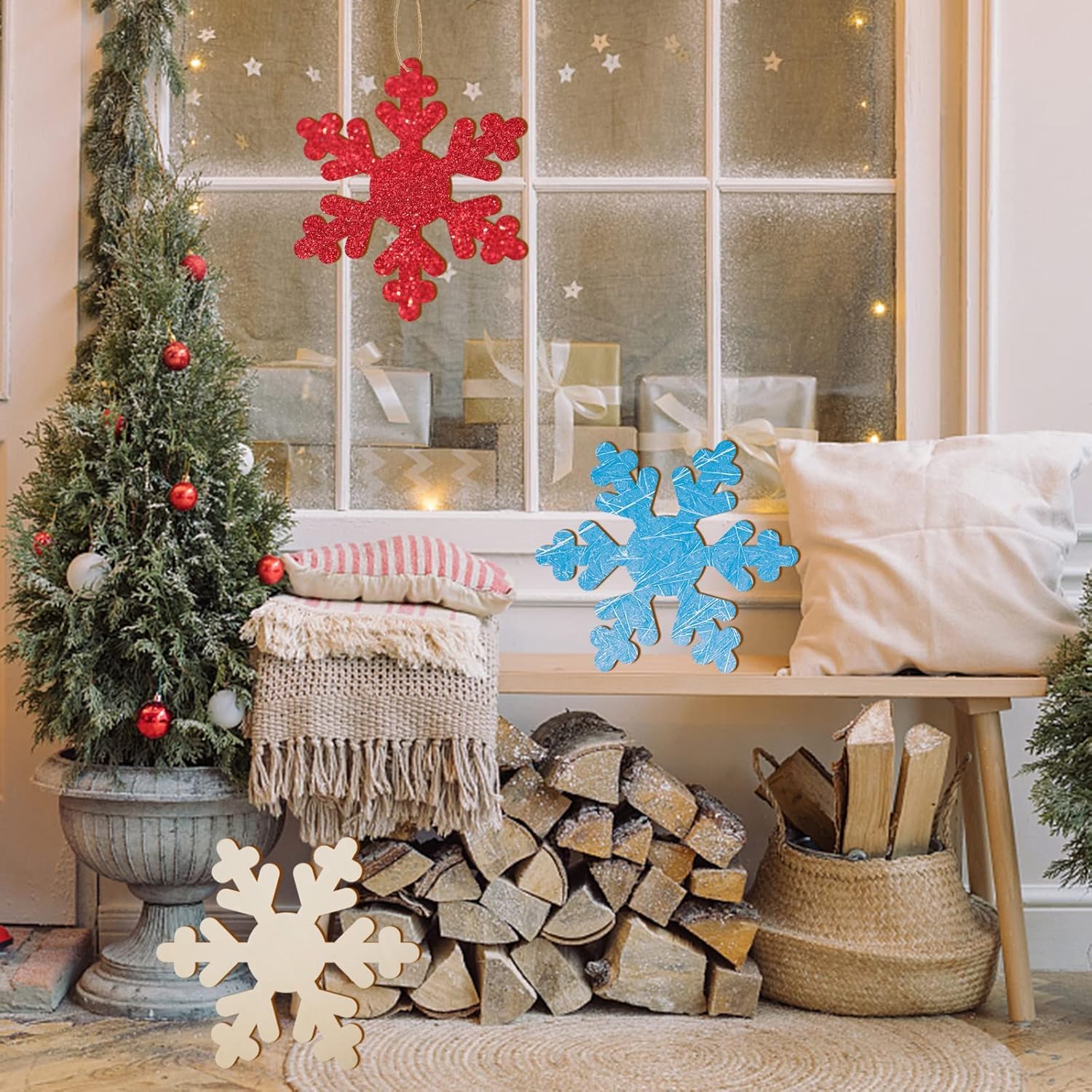 Cozy living room with Christmas decorations, including a tree, snowflakes, and stacked firewood.