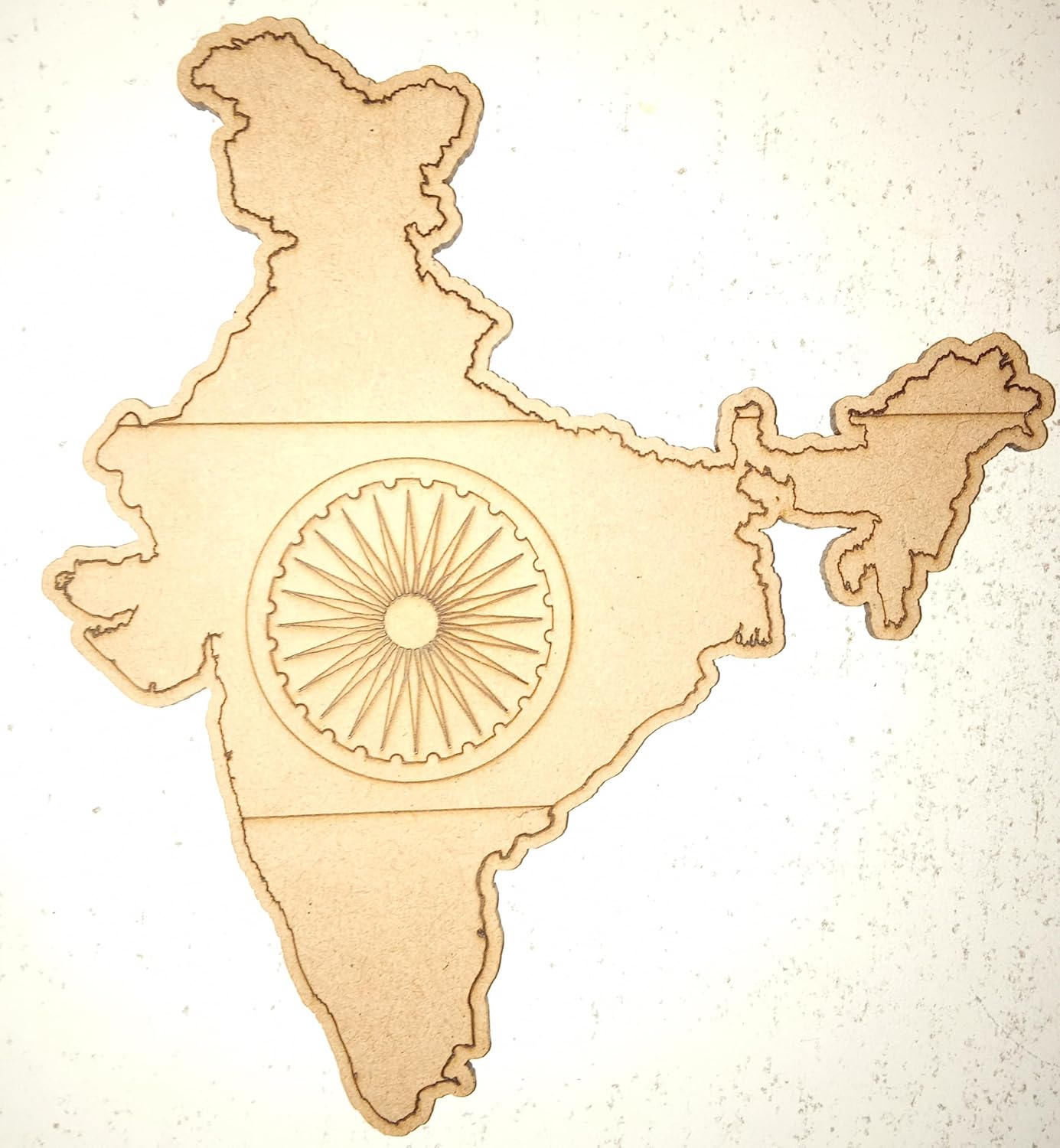 Wooden cutout of a map of India with the Ashoka Chakra in the center on a light background