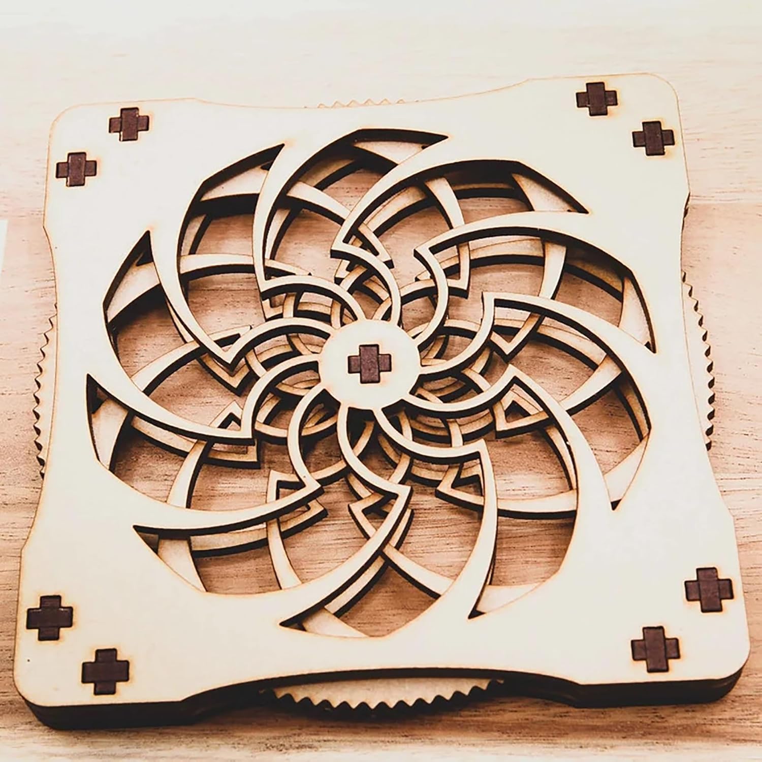 Wooden cooling pad with intricate laser-cut design on a wooden surface