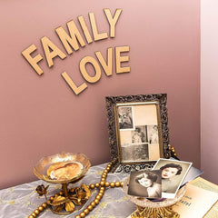 Decorative setup with 'FAMILY LOVE' text, framed photos, and decorative items on a table.