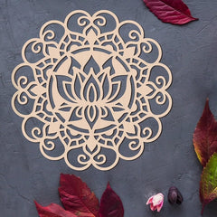 Decorative wooden mandala with intricate patterns on a dark surface with red leaves.