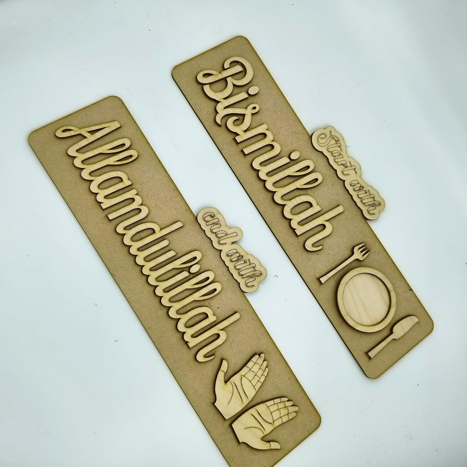 Wooden cutouts with engraved text and symbols on a white background