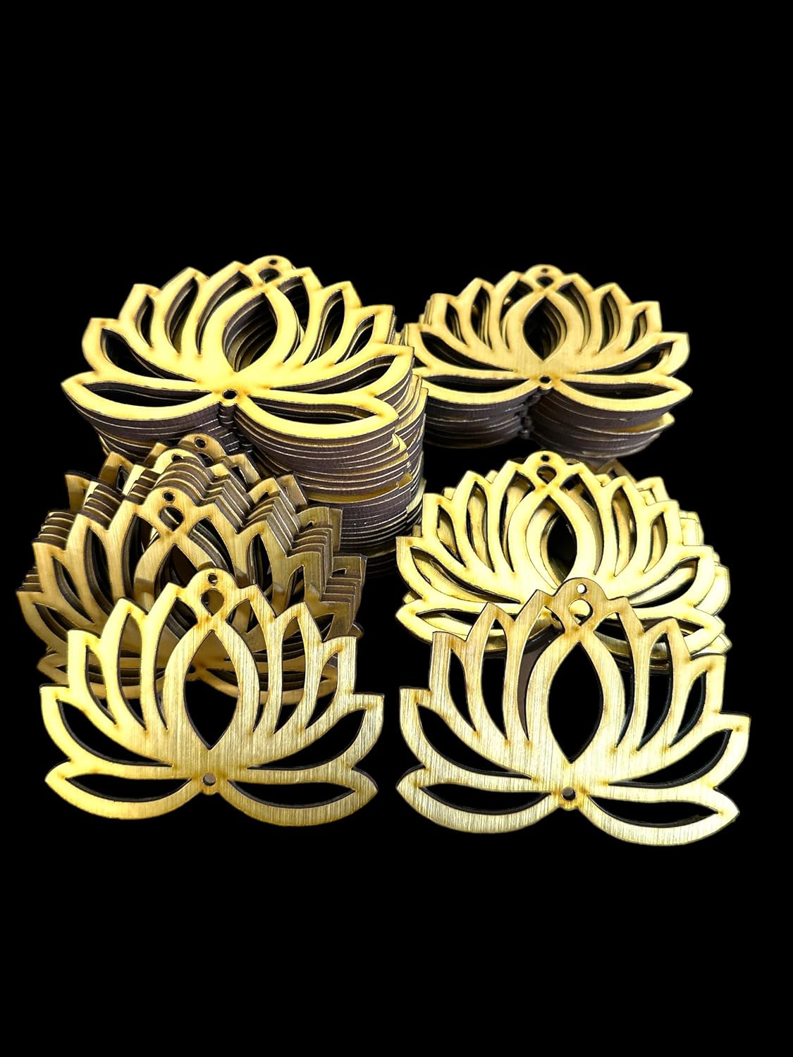 Gold lotus-shaped coasters stacked on a black background