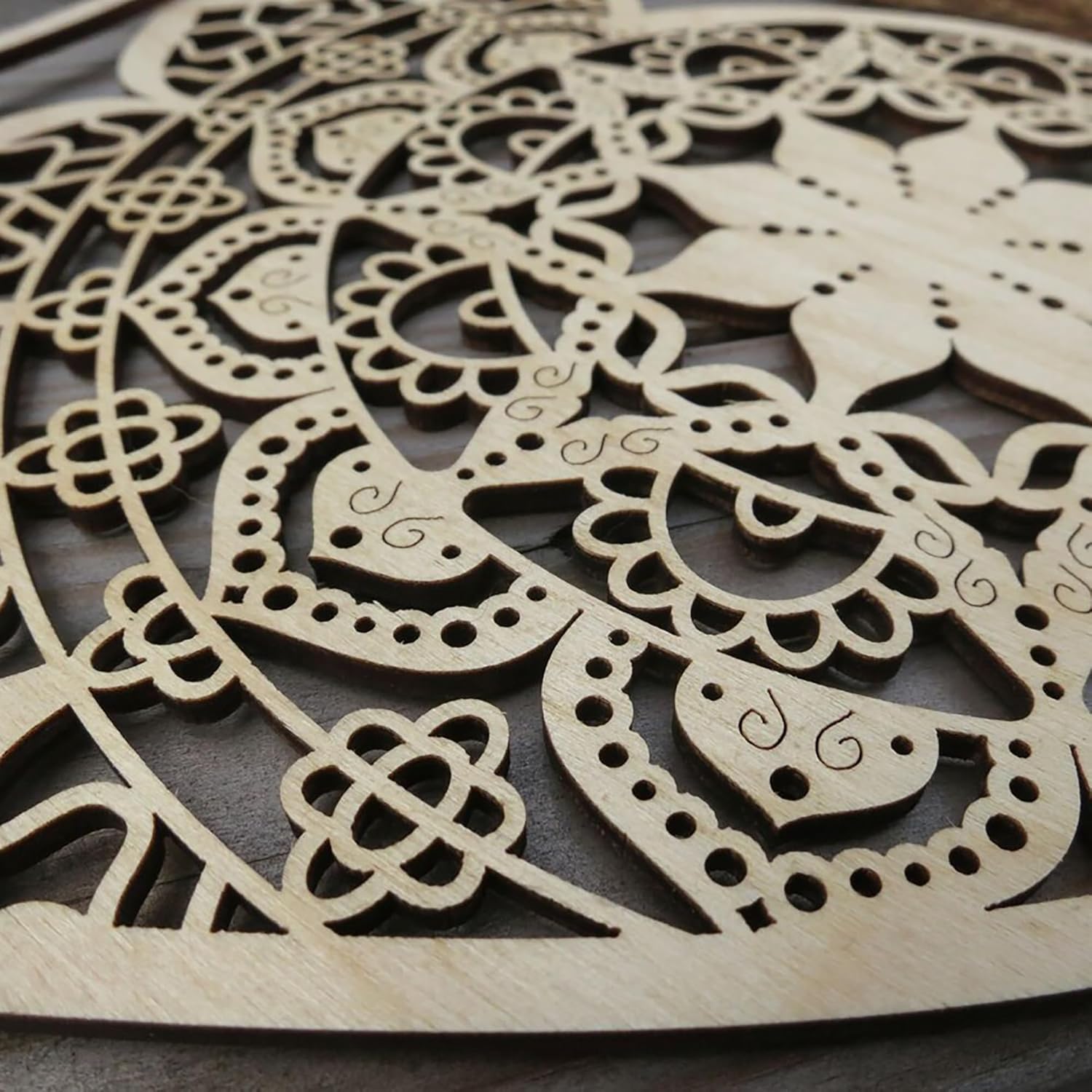 Wooden decorative panel with intricate cut-out patterns on a dark surface