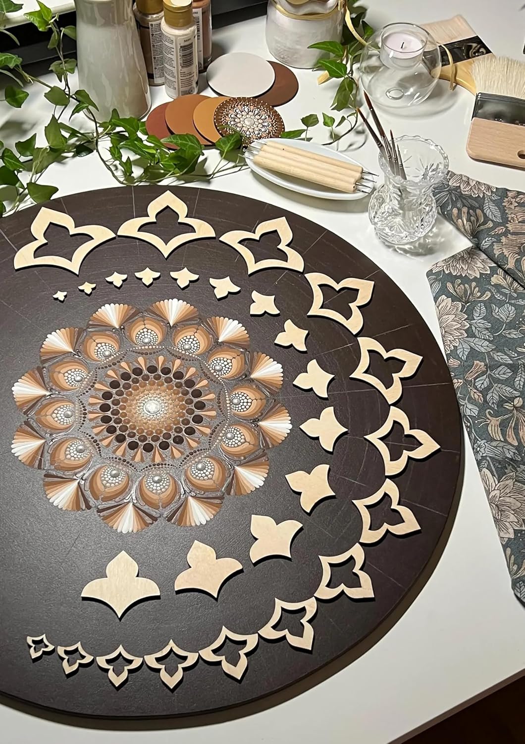 Decorative round mat with intricate cut-out patterns on a white surface.