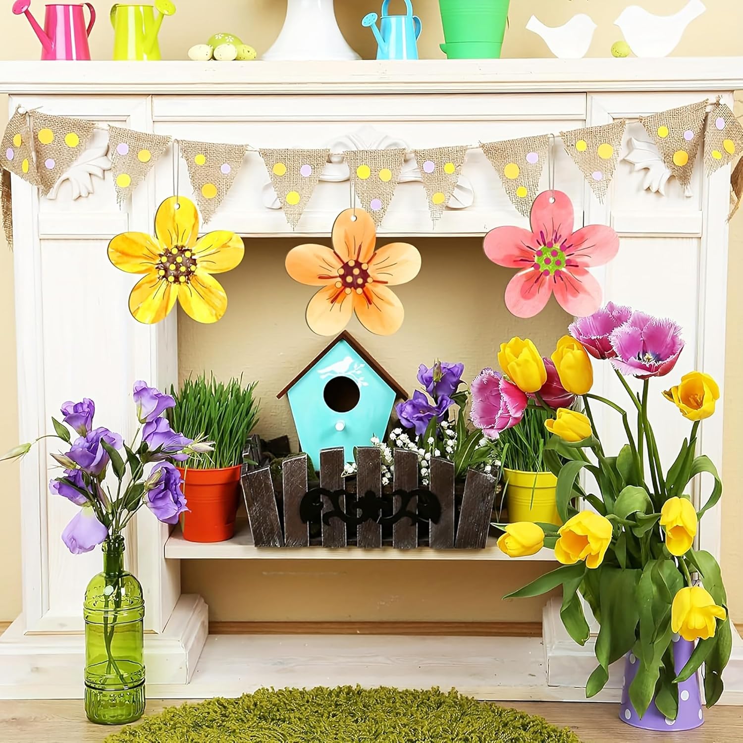 Decorative setup with flowers, a birdhouse, and a fence on a shelf.