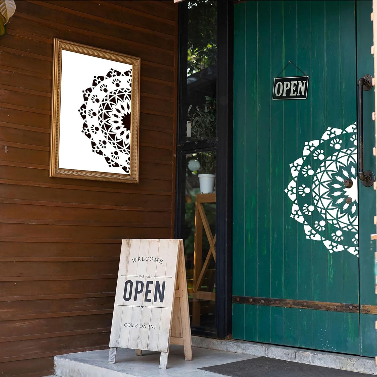Green door with decorative pattern, wooden sign, and framed artwork on a wooden wall.