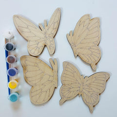 Four wooden butterfly shapes with paint containers on a white background