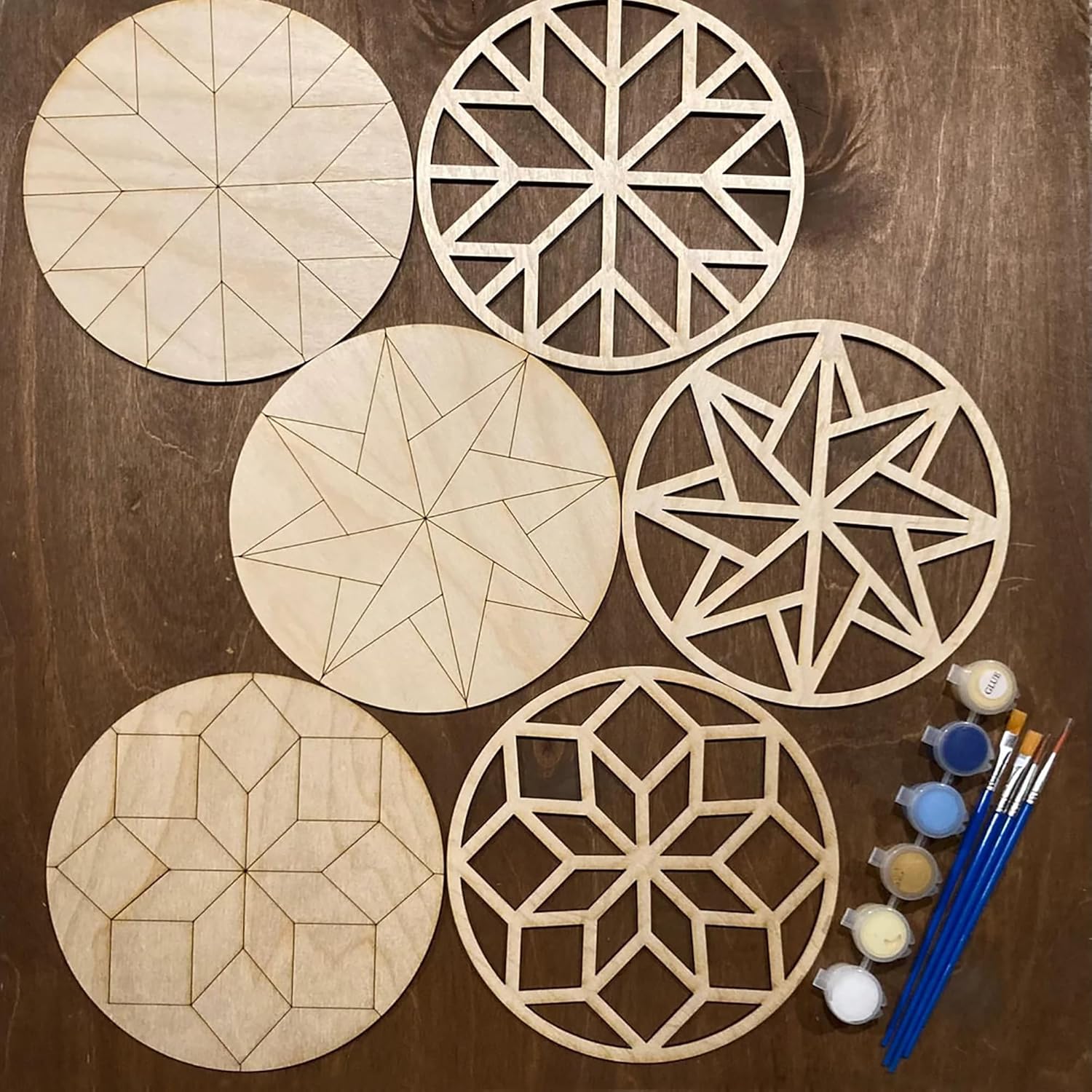 Set of wooden geometric shapes with paint and brushes on a wooden surface