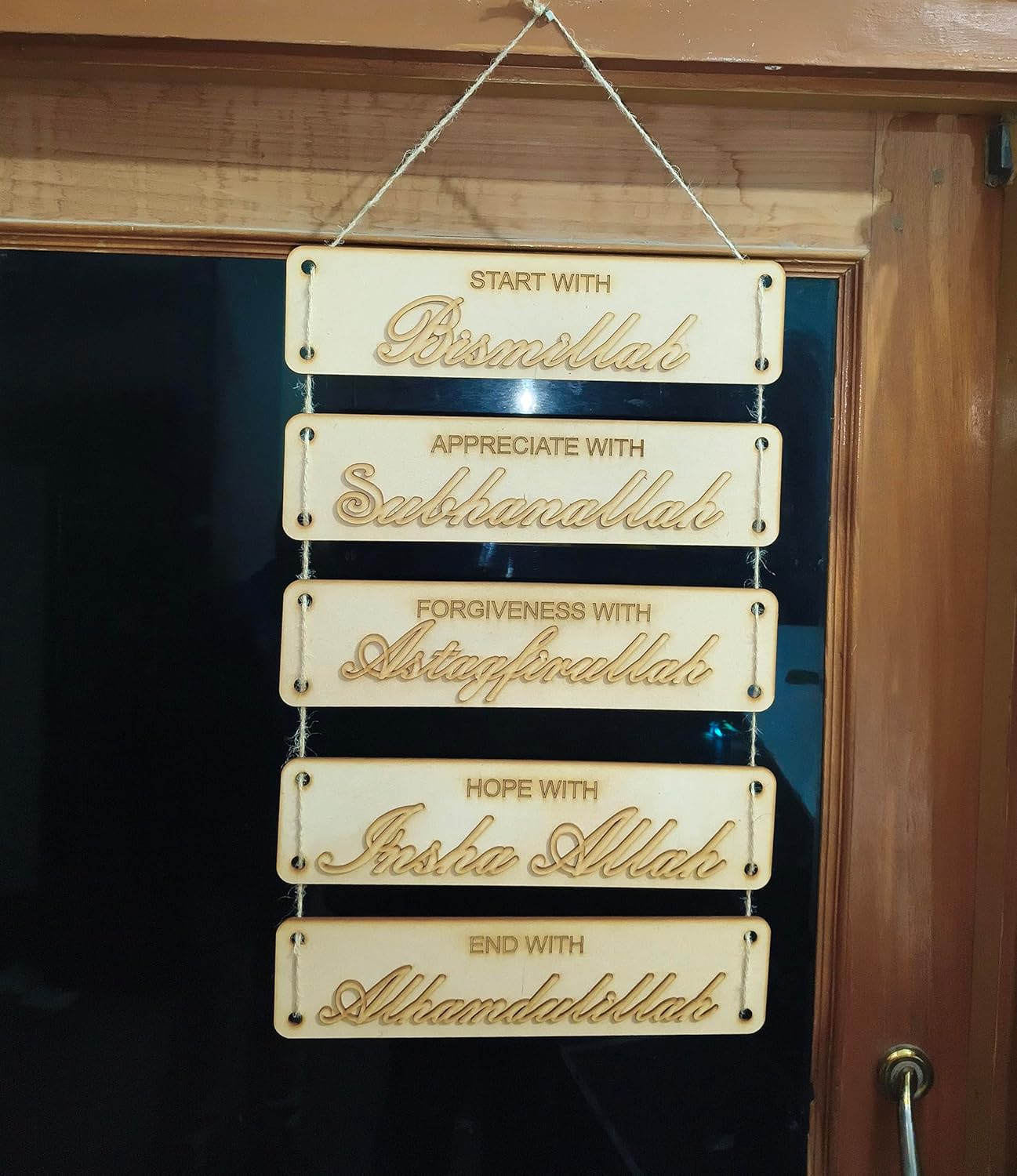 Decorative wall hanging with engraved phrases on a wooden background