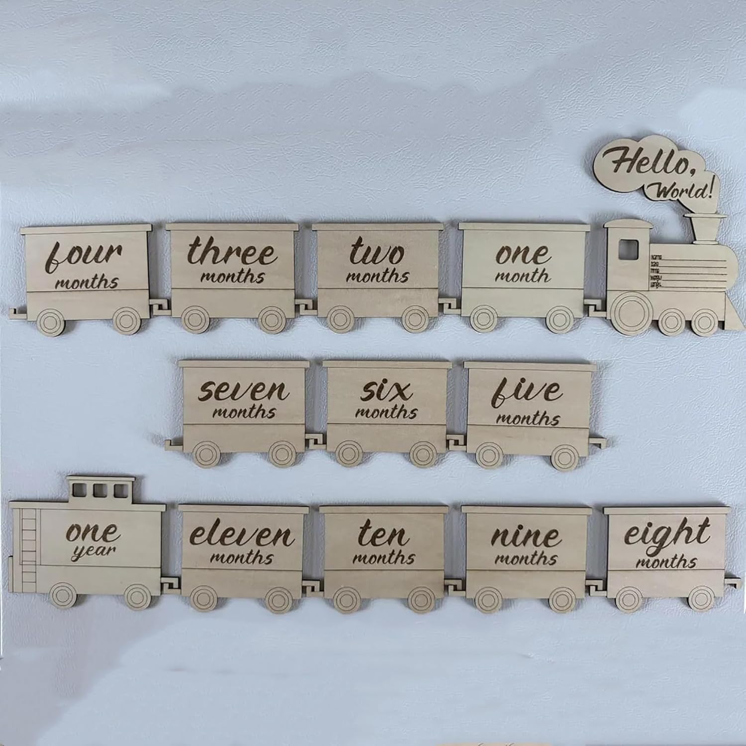 Wooden baby milestone train with month markers on a light blue background