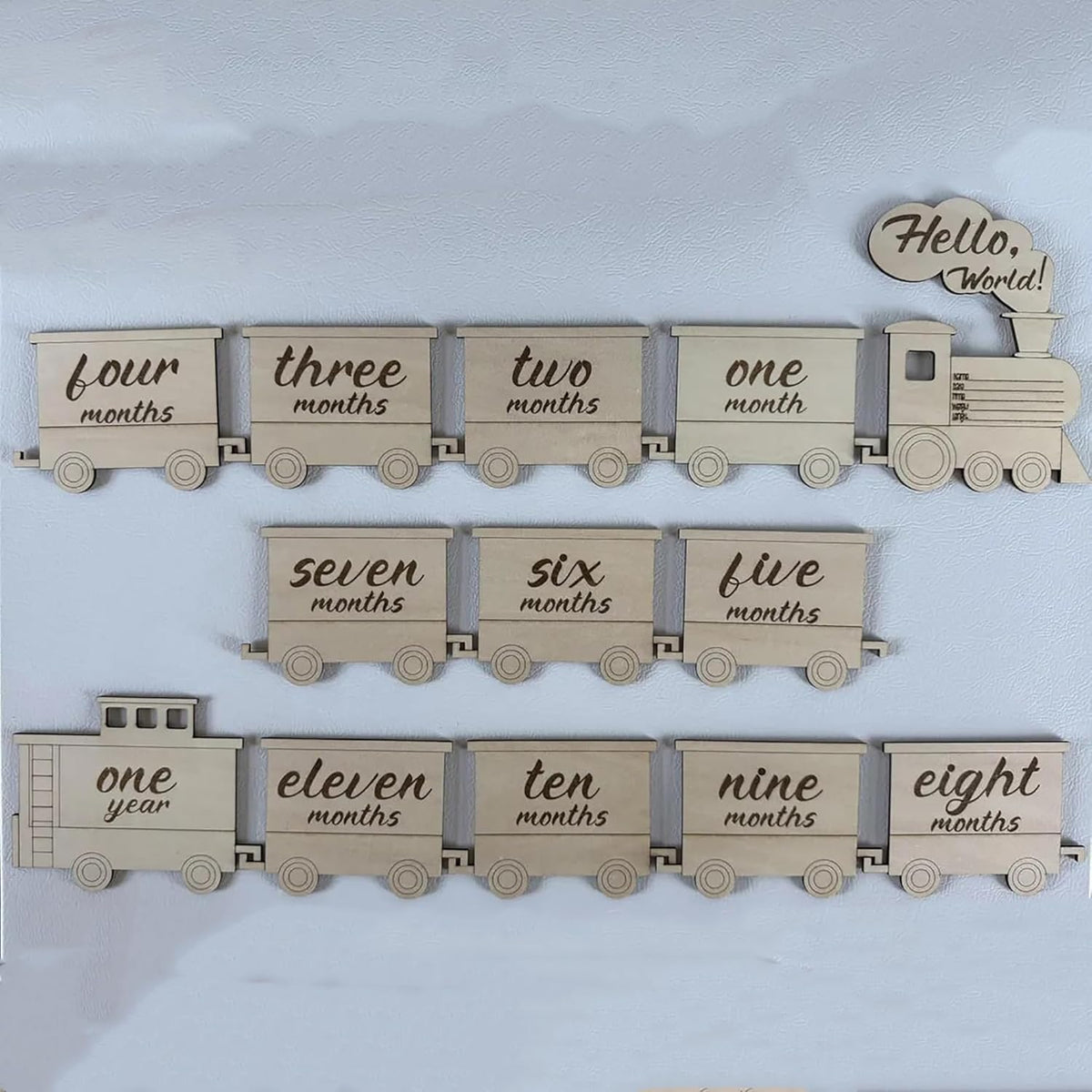 Wooden baby milestone train with month markers on a light blue background