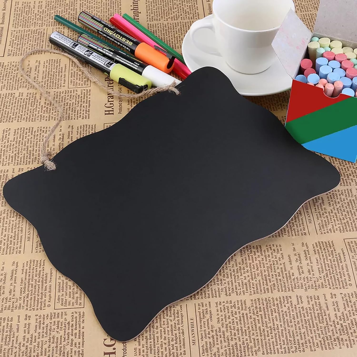 Black mouse pad on a newspaper background with stationery items.