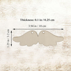 Two angel wing-shaped metal tags with measurements on a wooden background