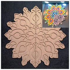 Decorative cardboard cutout of a snowflake design with a colorful mandala overlay on a dark background.