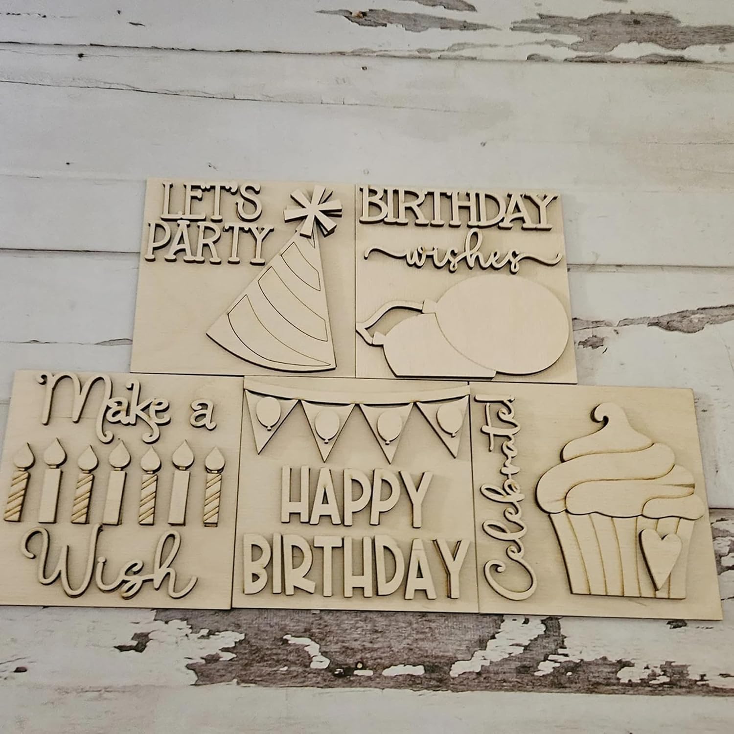 Wooden birthday-themed cutouts with phrases on a rustic wooden background