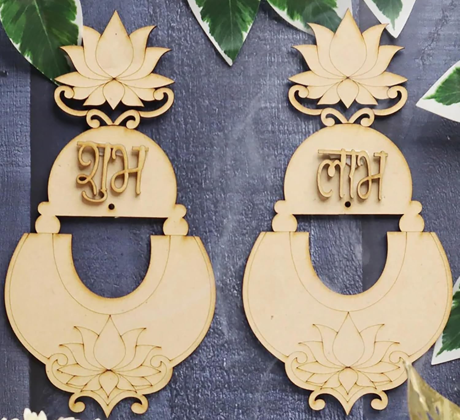 Pair of decorative earrings with lotus designs and script on a textured surface.