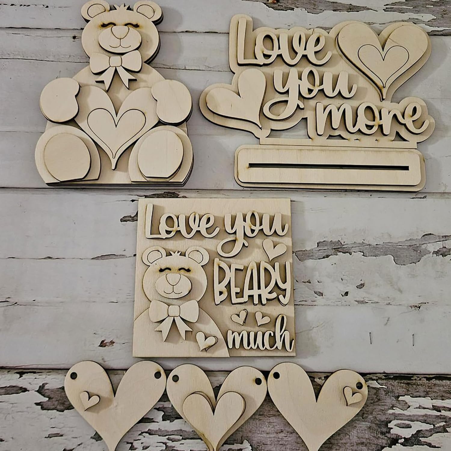Wooden decorative items with 'Love you more' and 'Love you BEARY much' text on a rustic wooden background.