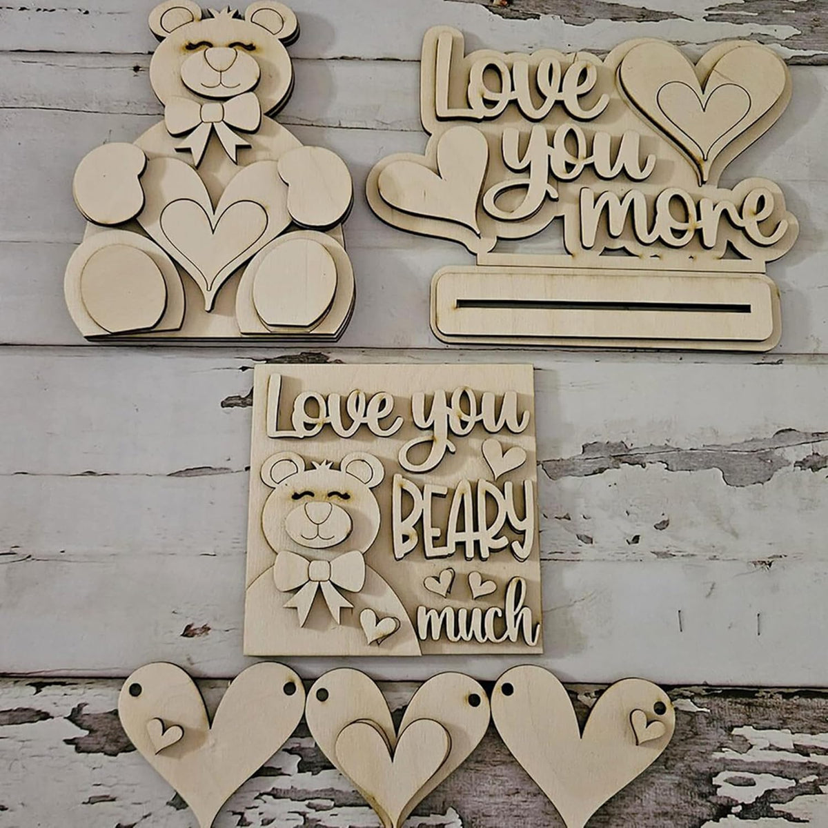 Wooden decorative items with 'Love you more' and 'Love you BEARY much' text on a rustic wooden background.