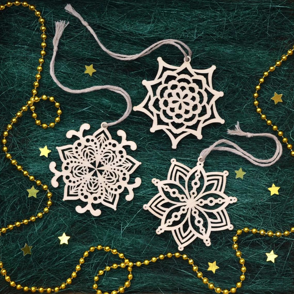 Decorative snowflake ornaments on a textured green background with gold beads and stars.