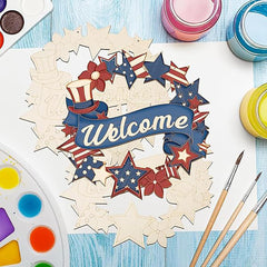 Wooden wreath with 'Welcome' text and patriotic design on a blue surface with paint supplies.