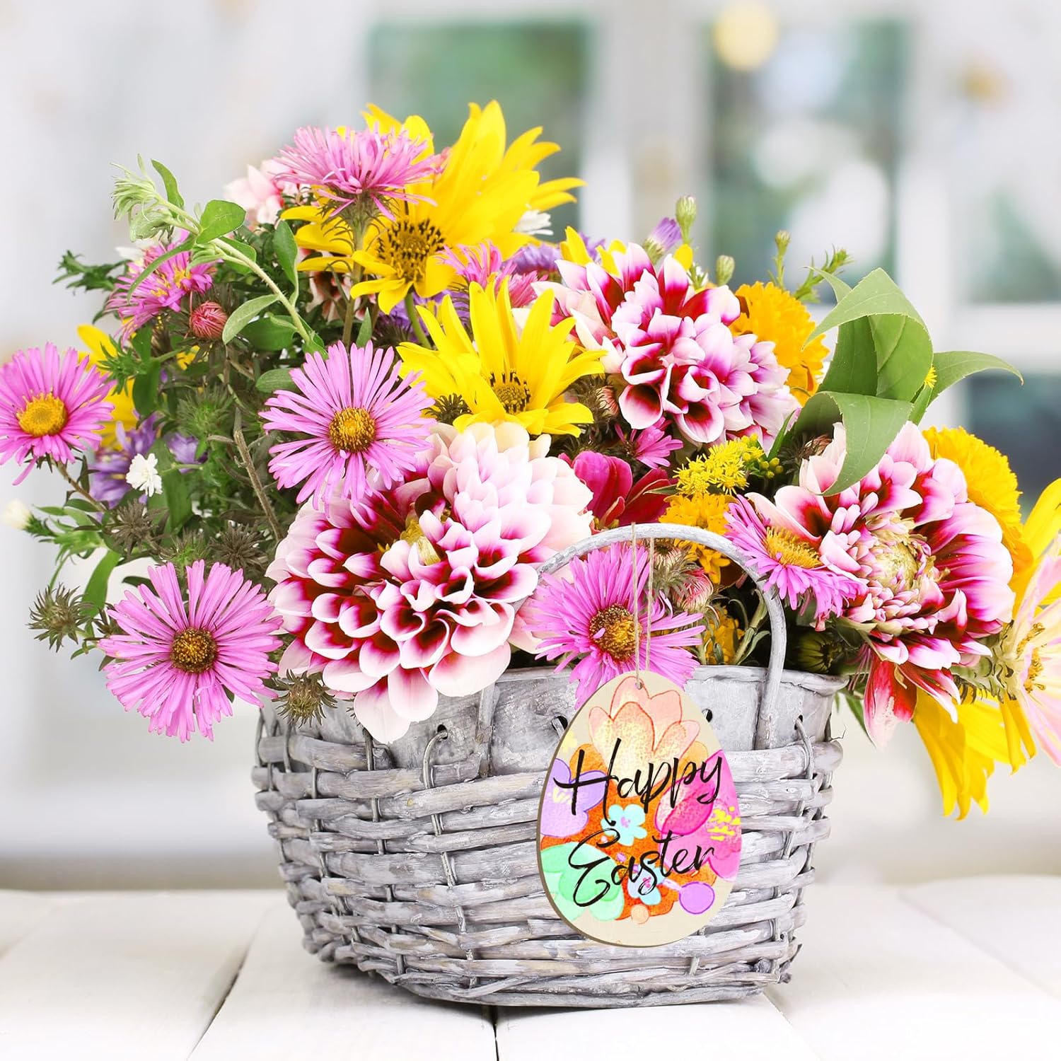 Basket of colorful flowers with a 'Happy Easter' tag on a blurred background