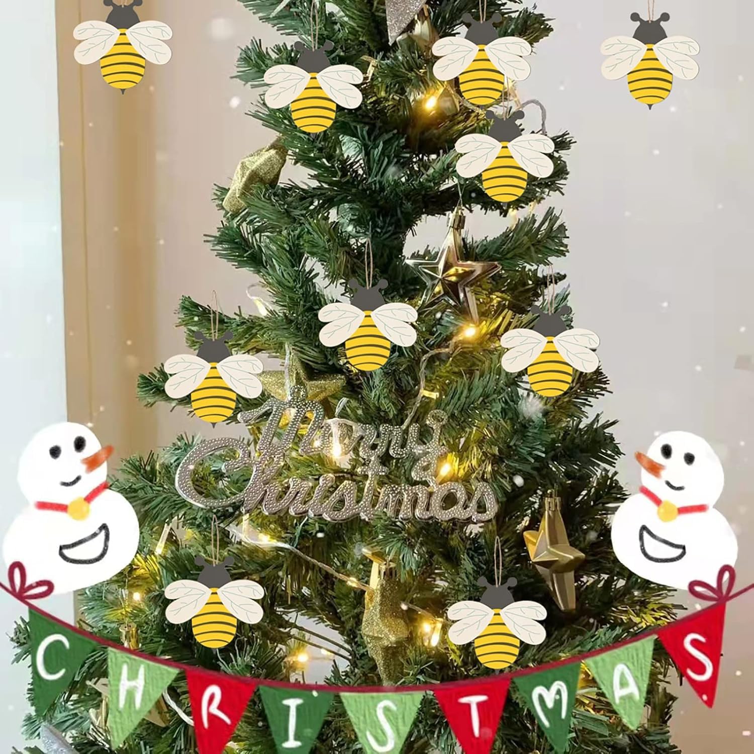 Decorated Christmas tree with bee-shaped ornaments and a 'Merry Christmas' banner.