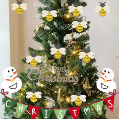 Decorated Christmas tree with bee-shaped ornaments and a 'Merry Christmas' banner.
