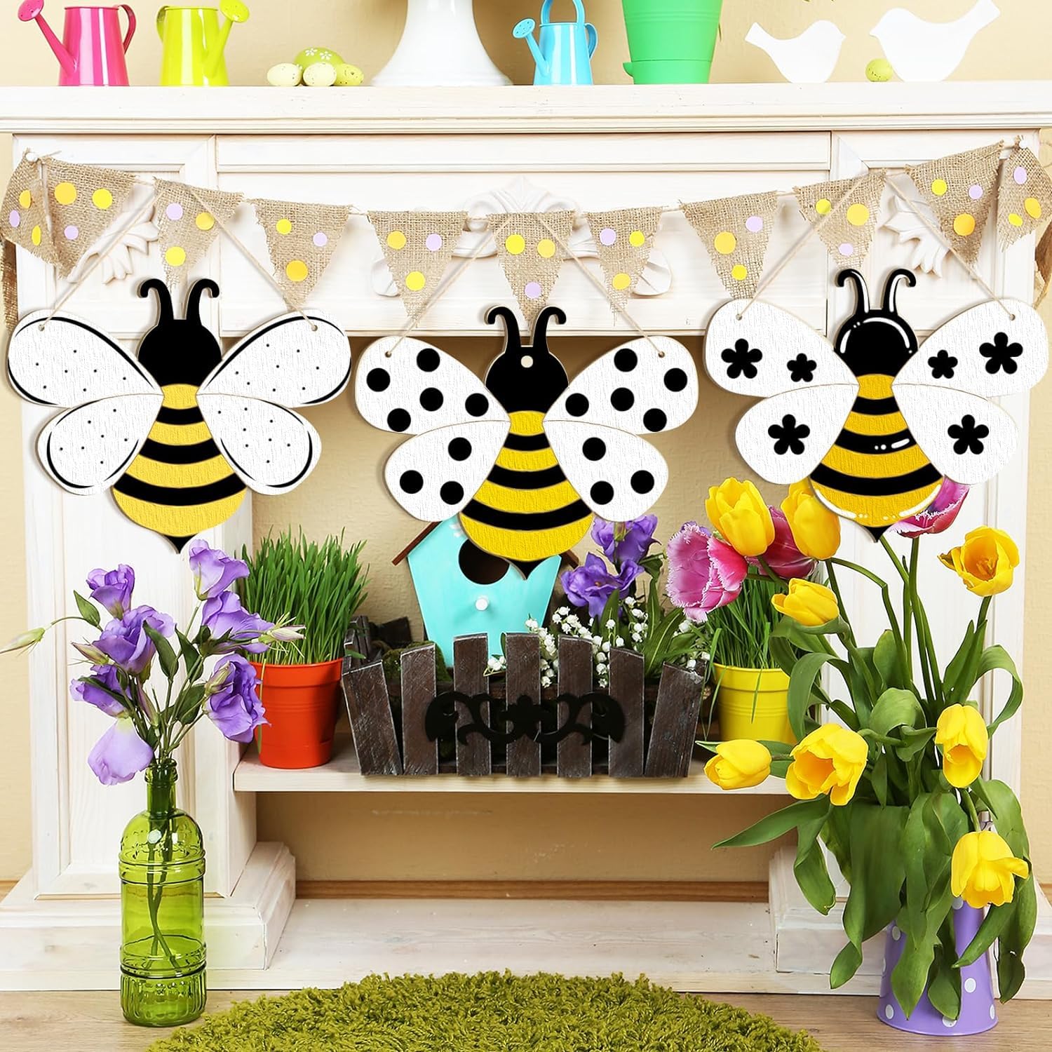 Decorative bee figures with flowers and plants on a shelf.