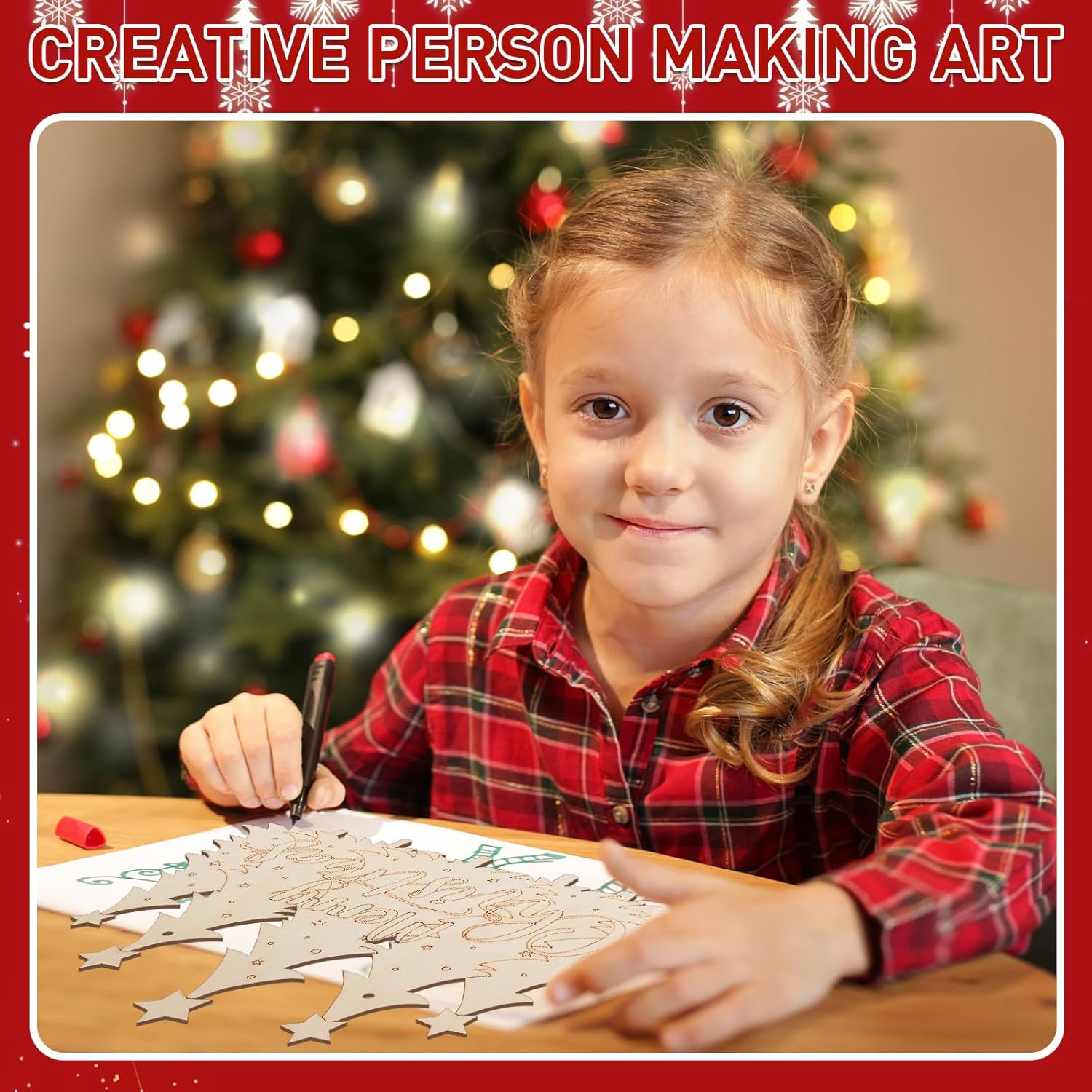 Child making art with a Christmas tree in the background
