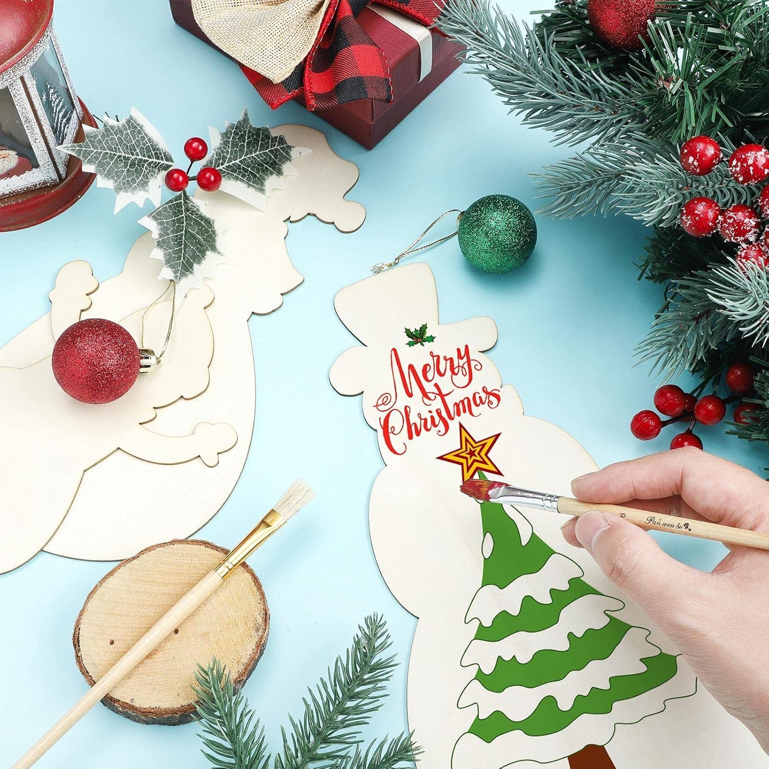 Decorative Christmas tree ornament with 'Merry Christmas' text, surrounded by festive elements on a light blue background.