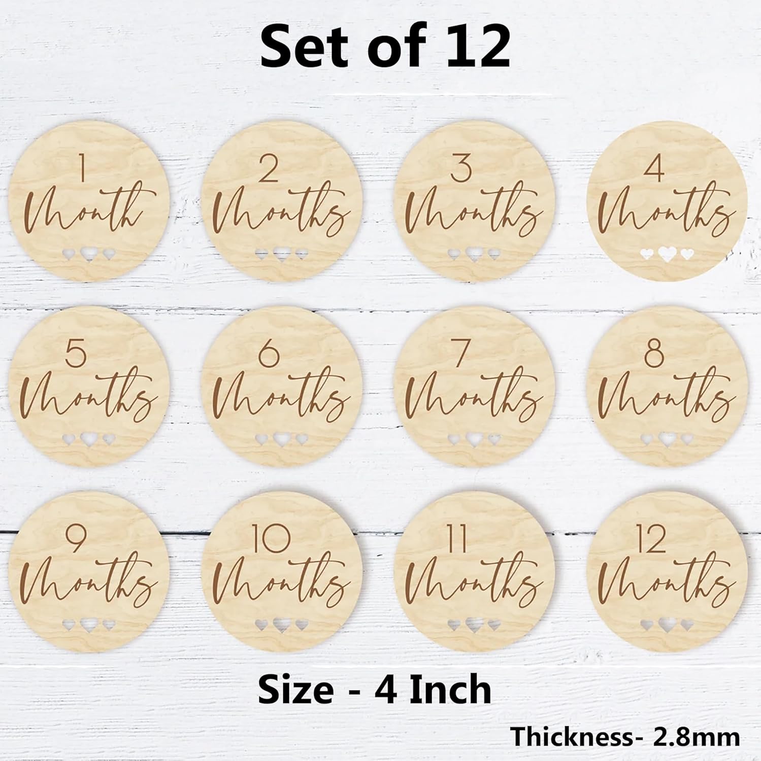 Set of 12 wooden milestone discs with months printed on them, displayed on a white wooden surface.