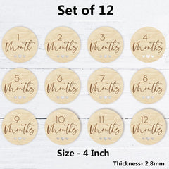 Set of 12 wooden milestone discs with months printed on them, displayed on a white wooden surface.