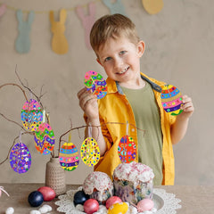 Child holding colorful Easter egg decorations with a decorated cake and Easter eggs on a table.
